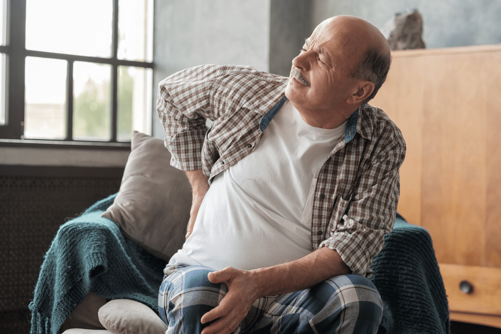 Man dealing with severe sciatica caused from spinal stenosis. 